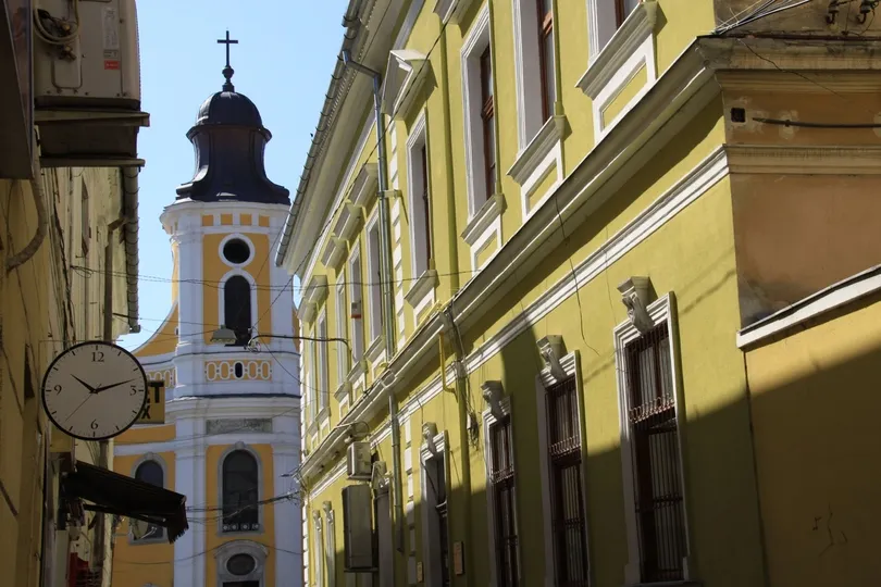 Eine Gasse in der Bukarester Innenstadt in Rumänien. Eine alte Kirche und Fachwerkhäuser sind sichtbar.