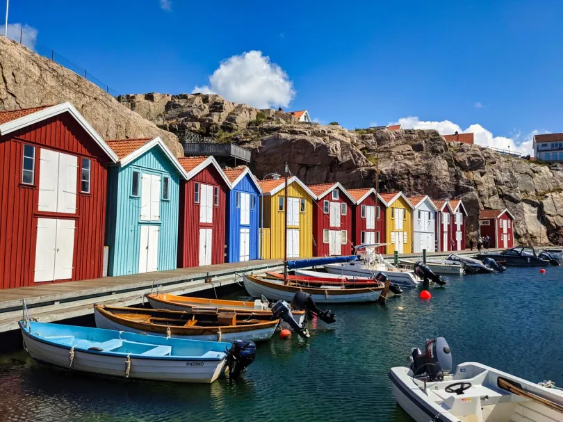 Ein kleiner Hafen in Schweden mit typisch bunten schwedischen Häusern und kleinen Motorbooten.