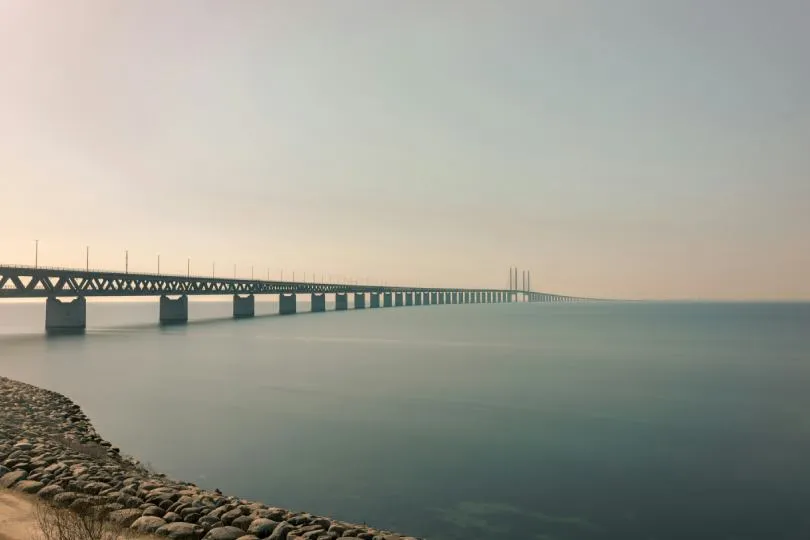 Öresundbrücke zwischen Dänemark und Schweden, die sich über ruhiges Wasser unter klarem Himmel erstreckt.