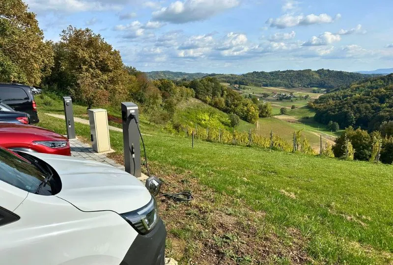 Elektriche Autos an der Ladestation in einer grünen hügeligen Landschaft in Kroatien.