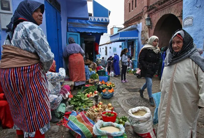 Dame verkauft ihr Gemüse auf der Straße in Marokko. eine Interessentin steht ihr gegenüber.