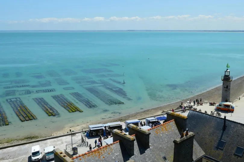 Küstenstadt Cancale mit vielen Austerkörben im Wasser.