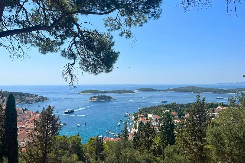 Schöne Aussicht in Kroatien auf das Meer, das grüne Land davor und die Häuschen mit roten Dächern dazwischen.