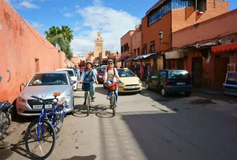 Zwei Fahrradfahrer fahren durch die bunten Straßen Marokkos. 