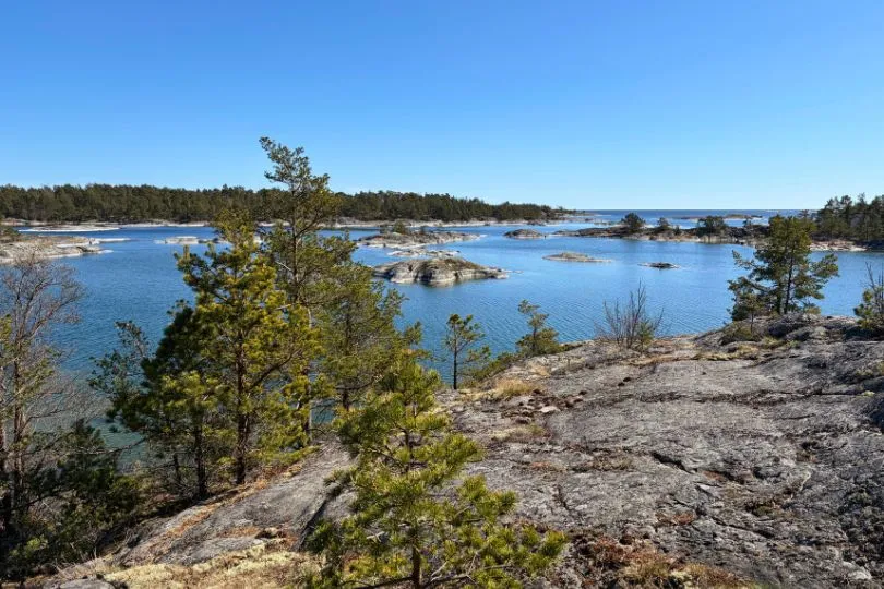 Schäreninseln in Schweden, geprägt von rauen Felsen, Nadelbäumen und blauem Wasser.