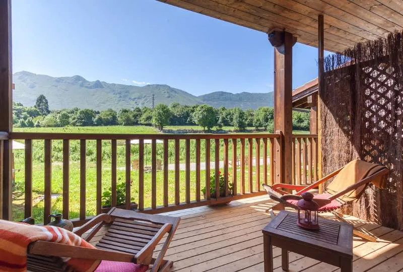 Terrasse mit Holzmöbeln und grüner Aussicht in Spanien.