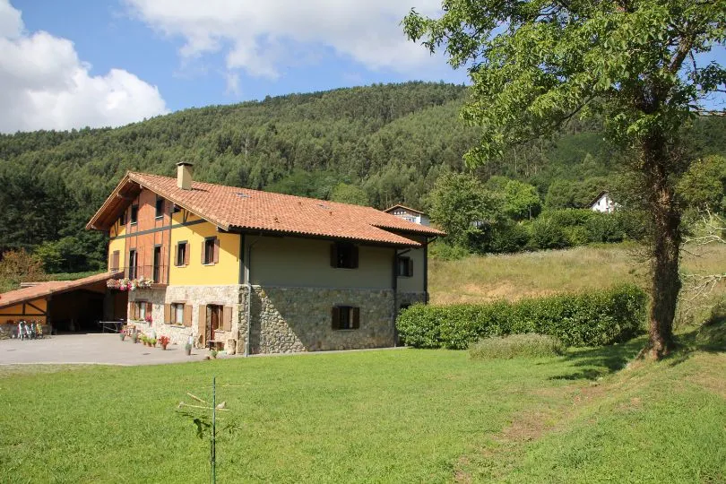 Unterkunft mitten auf einer Wiese und vor einem waldigen Hügel in Asturien, Spanien.