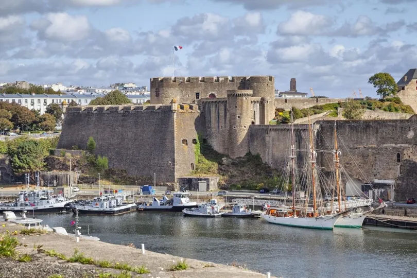 Het oude kasteel in Brest, Bretagne, aan een kleine haven met bootjes in het water.