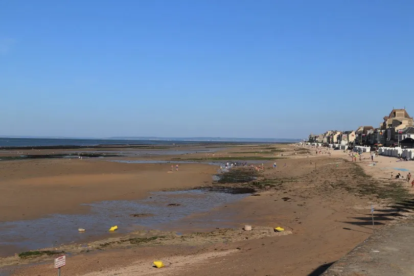Der lange Strand von Saint-Aubin-sur-Mer mit vielen Menschen die das Wetter genießen.