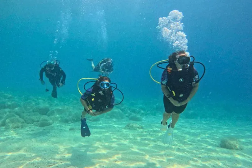 Scuba Taucher im Wasser des Drymades Strandes in Palasë, Albanien.