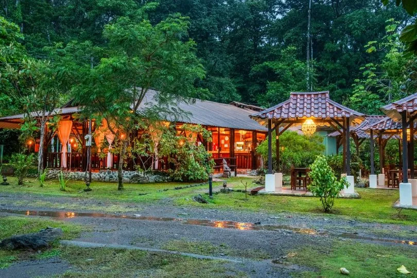 Die Hacienda Baru Lodge in Costa Rica steht erleuchtet im nassen Regenwald.