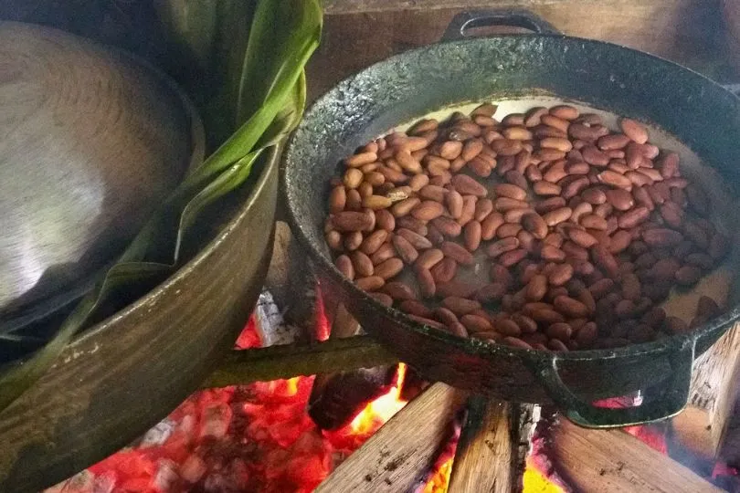 Kakaobohnen rösten in einer Pfanne bei der Schokoladenherstellung mit der Bribri Gemeinschaft in Costa Rica.