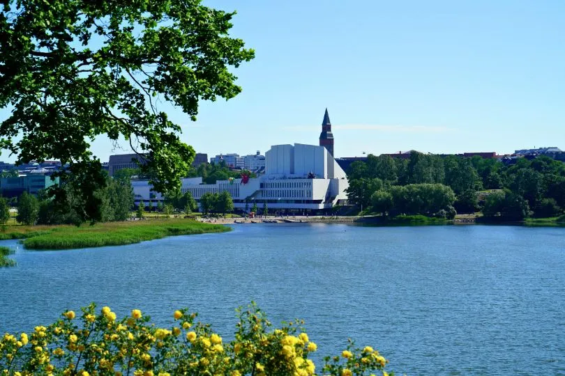 Ein modernes weißes Gebäude steht vor einem See in Finnland.