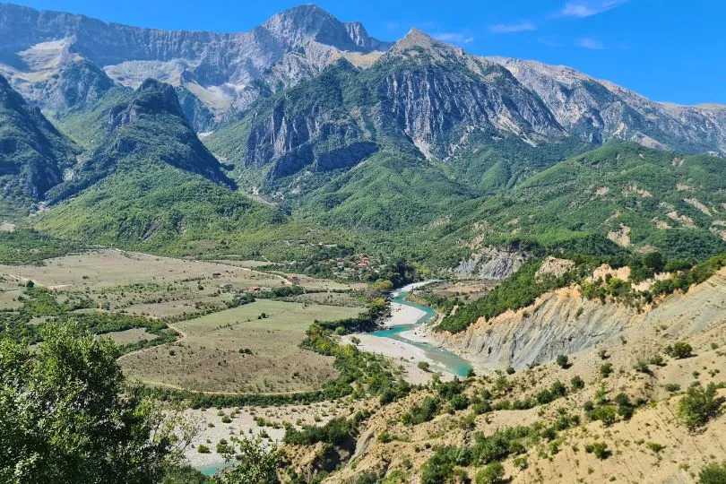Ein türkiser Fluss schängelt sich durch eine beeindruckende Berglandschaft in Normazedonien.