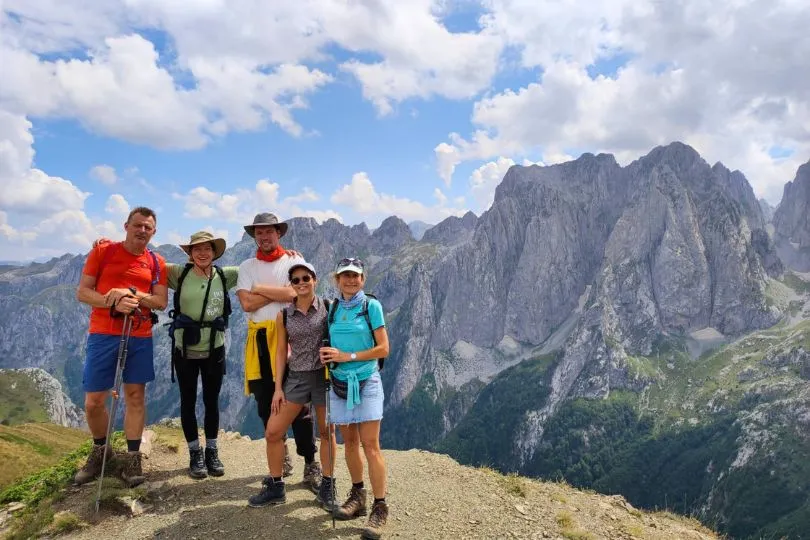 5 Freunde posieren vor felsigen Bergen auf einer Wandertour in Montenegro.