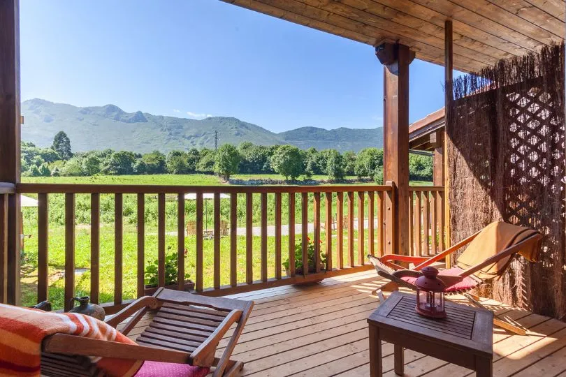 Gemütliche Holzterrasse mit Liegestühlen und Aussicht aufs Grüne in Spanien.