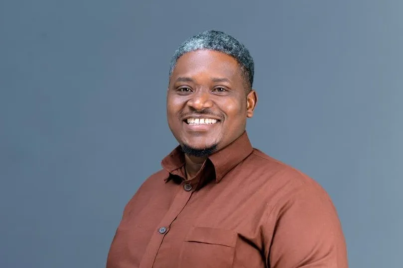 Portaitfoto afrikanischer Mann vor grauem Hintergrund.