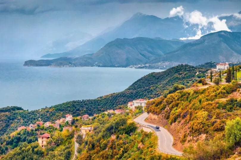 Küstenstraße in Albanien führt über Berge voller Vegetation direkt am Meer entlang.