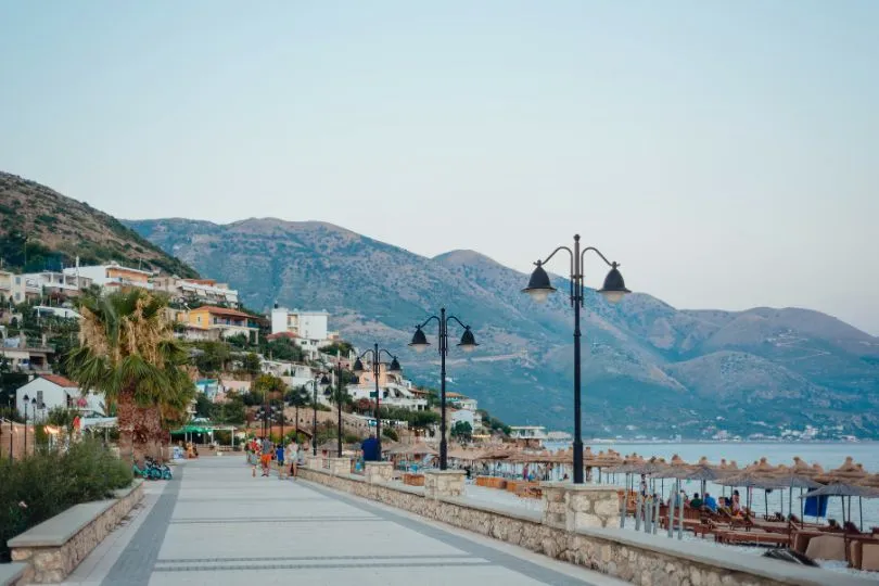 Eine Promenade am Meer von Albanien, direkt neben den aufragenden Bergen.