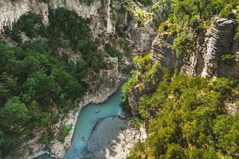 Ein türkiser Fluss windet sich durch eine steile Schlucht in Albanien.