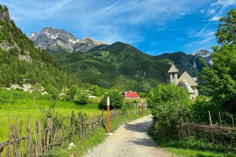 Landstraße in Albanien führt zu einer kleinen Kapelle inmitten der Berge.