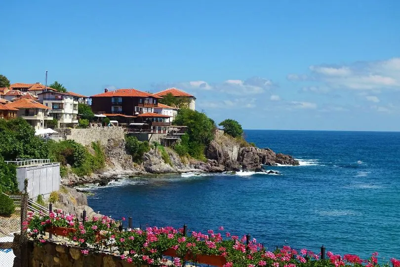 Häuser mit roten Dächern stehen an einer niedrigen Klippe am Meer in Sozopol, Bulgarien.