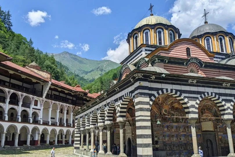 Das bunt gestreifte Rila Kloster in Bulgarien mit Bergen im Hintergrund.