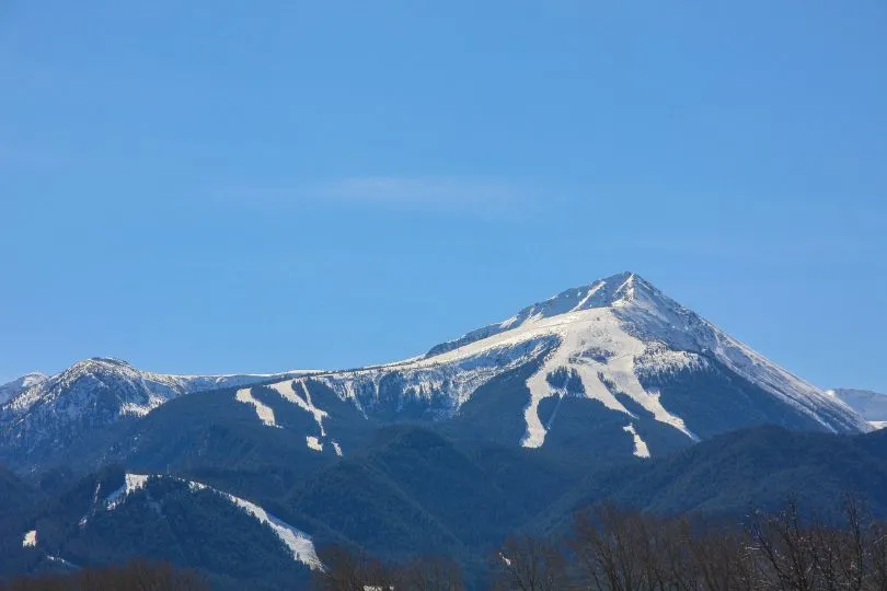 Der schneebedeckte Vihren Gipfel in Bulgarien thront vor dem blauen Himmel.