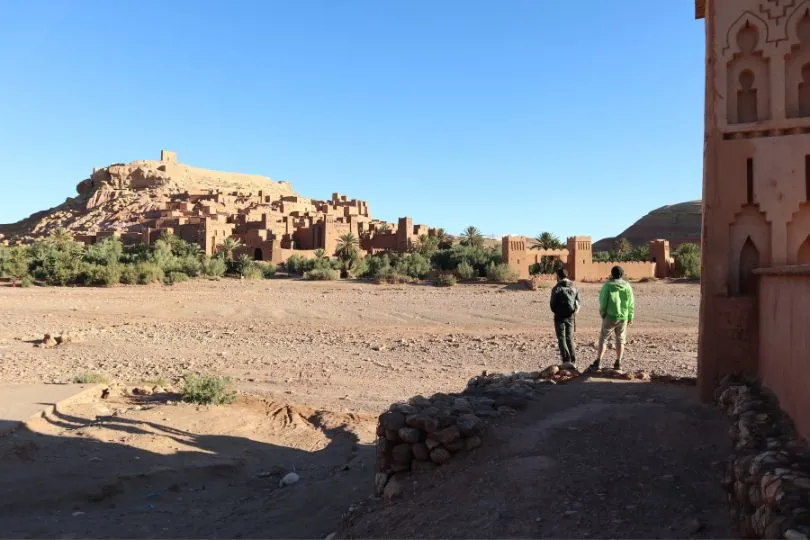 Zwei Touristen stehen vor Aid-ben-Haddou in Marokko.