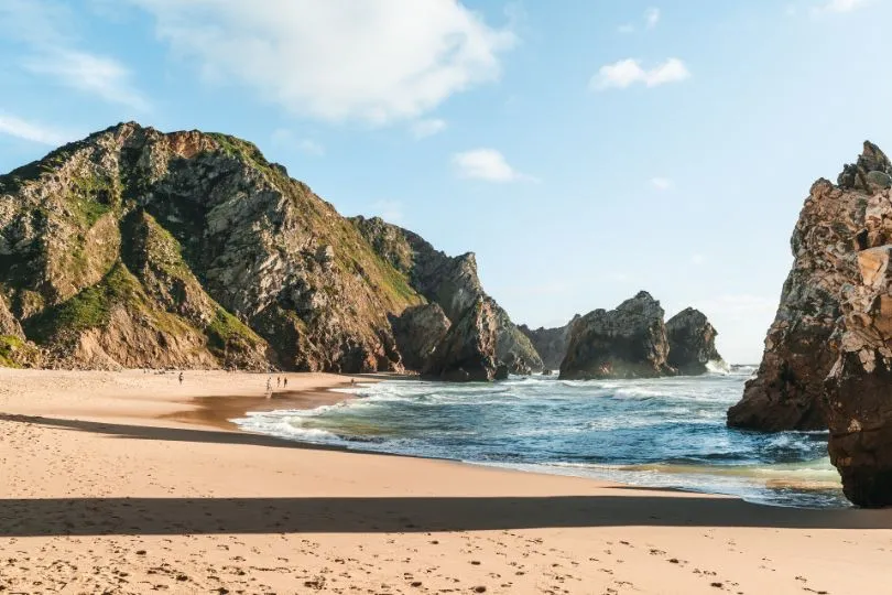 Steile Felsen ragen aus dem Meer am Strand an der Praia da Ursa in Portugal.