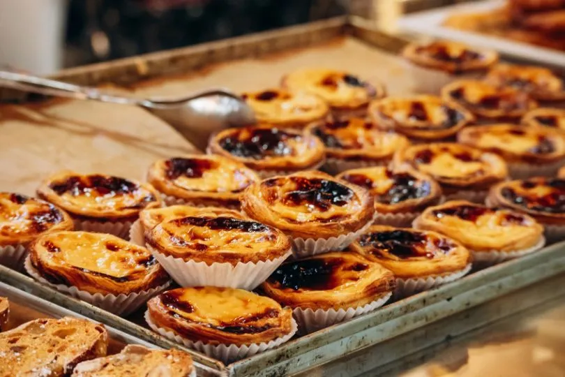 Pastéis de Nata, eine traditionelle Süßigkeit in Portugal, liegen auf einem Tablett.