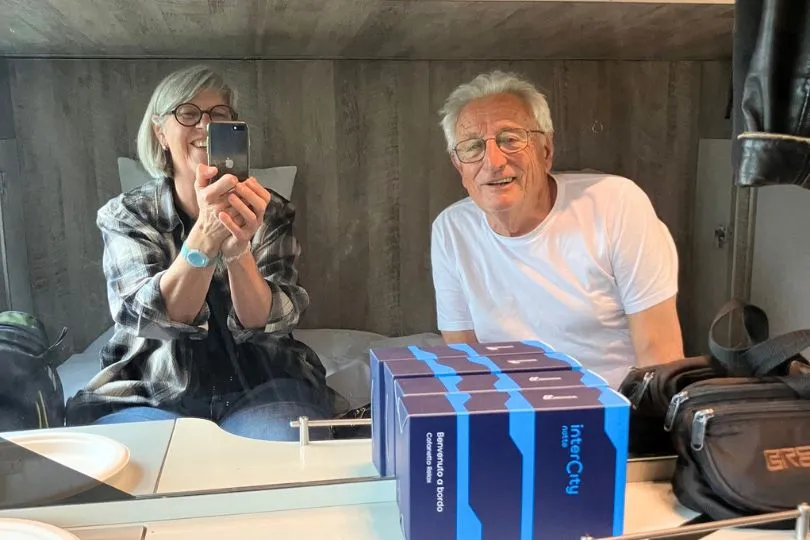 Ein paar sitzt in ihrem Abteil eines Nachtzugs nach Süditalien und mach ein Selfieim Spiegel.