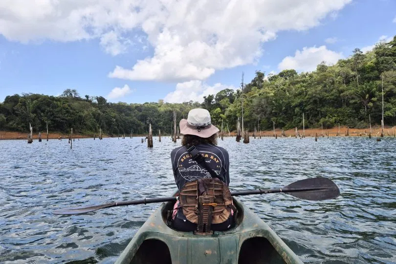 Reisende auf einem Kajak auf einem See im Dschungel Surinames.
