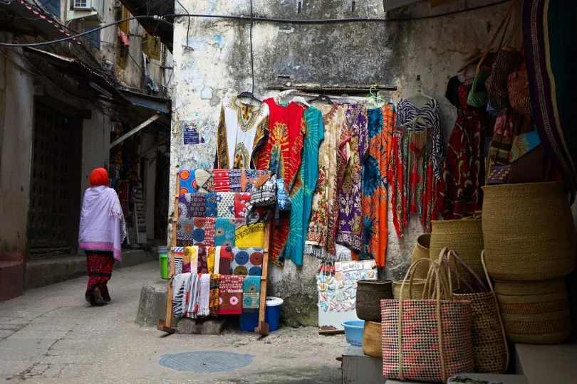 Colorful clothes and other products are displayed on the streets of Stone Town, Tansania, for sale. 