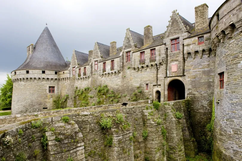 Historisches Château de Rohan in Pontivy in der Bretagne mit massiven Steinmauern, Rundturm, Burggraben und mittelalterlicher Architektur.