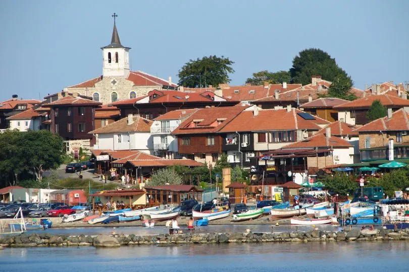 Die Altstadt von Nesebur in Bulgarien mit ihren roten Dächern hinter dem Hafen mit kleinen Booten.