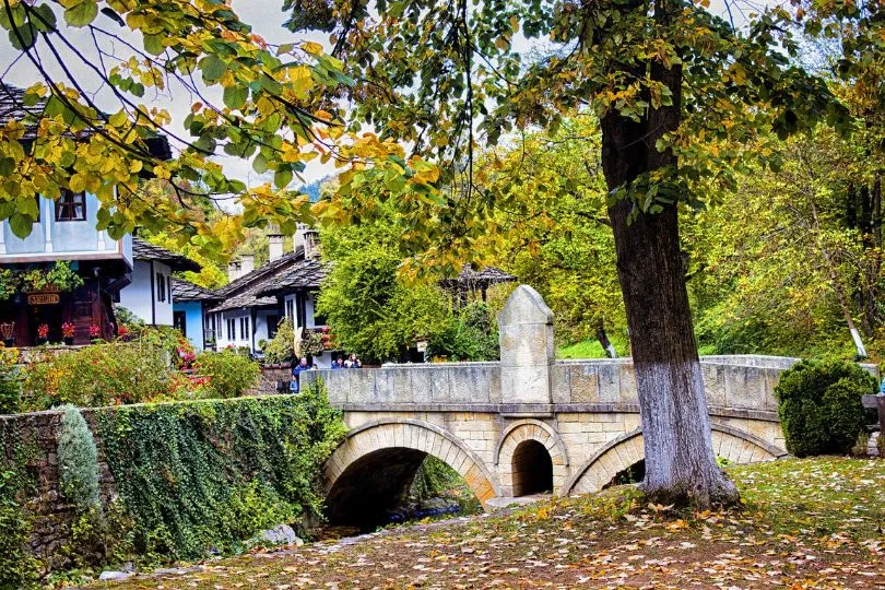 Kleine Steinbrücke in Gabrovo, Bulgarien, umgeben von Bäumen im gelben Herbstkleid.