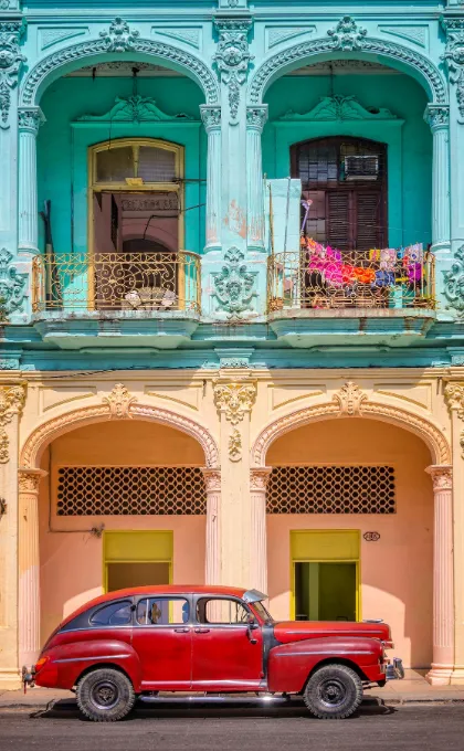 Türkis und orangenes Haus mit einem roten Auto