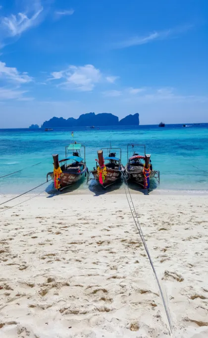 Drei Boote am weißen Strand von Koh Phi Phi