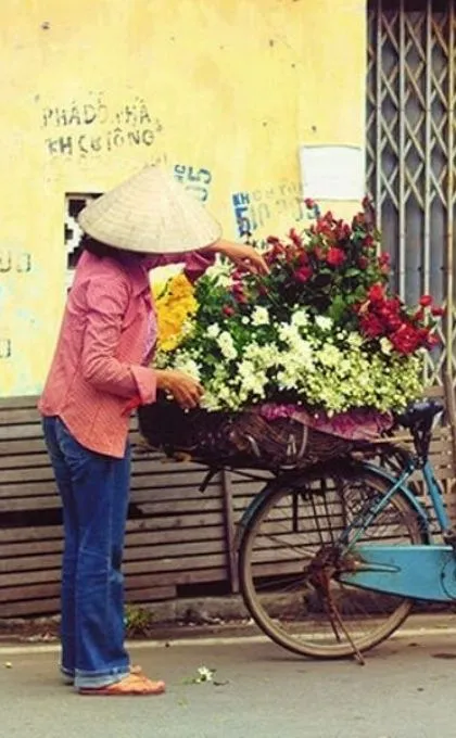 Einheimische mit geschmücktem Fahrrad in Vietnam