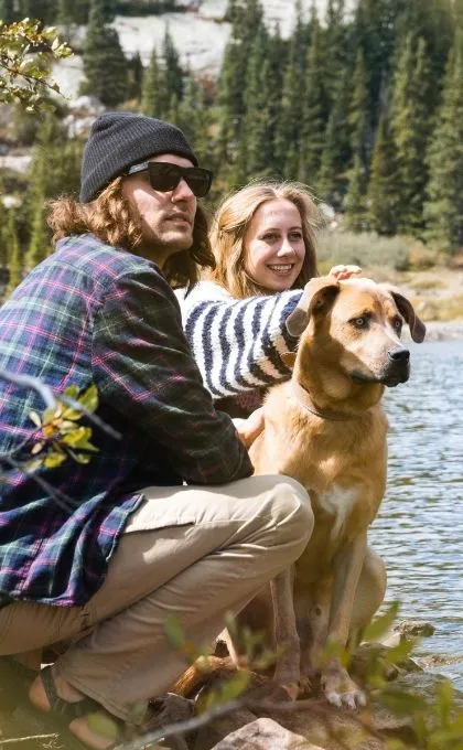 Ein Mann und eine Frau sitzen während ihres Mikroabenteuers am Fluss