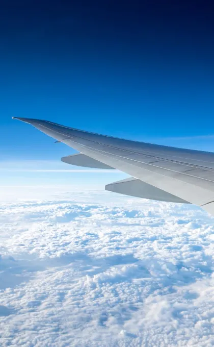 Ein Flugzeugflügel über den Wolken