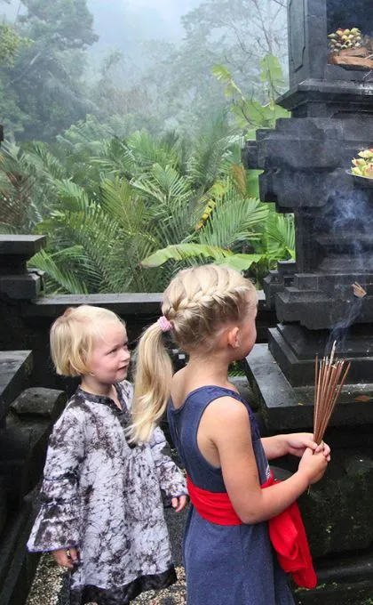 Kinder halten Räucherstäbchen während eines Tempelbesuchs in Indonesien.