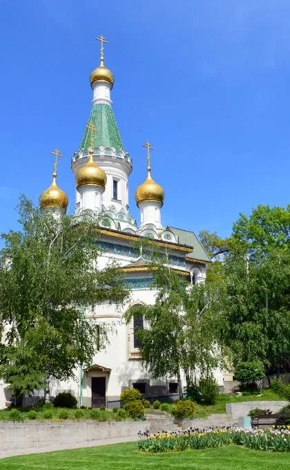Weiße Kirche in Bulgarien mit goldenen und türkisen Farbelementen.