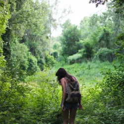 Eine Frau, die als Plastikreporter mitmacht, sucht nach Müll im Wald