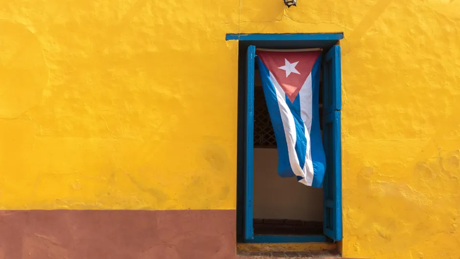 Gelbe Hauswand mit kubanischer Flagge