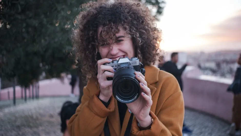 Eine Frau macht ein Foto, wie sie es beim Online Fotokurs gelernt hat
