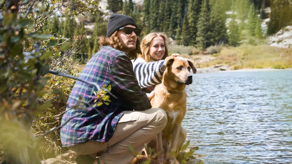 Ein Mann und eine Frau sitzen während ihres Mikroabenteuers am Fluss