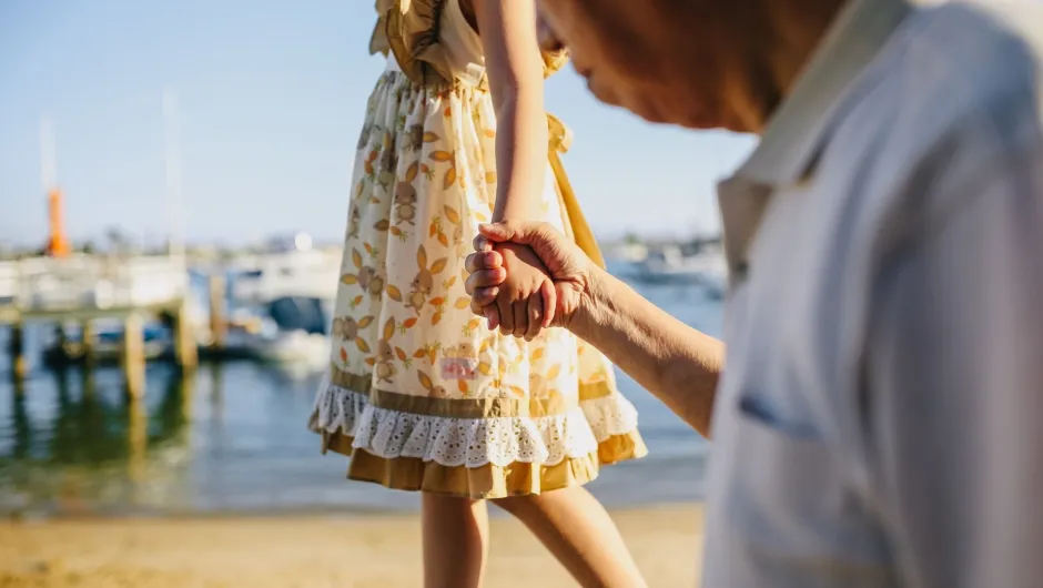 Bei einemMehrgenerationen Urlaub spaziert ein Kind auf einem Bordstein