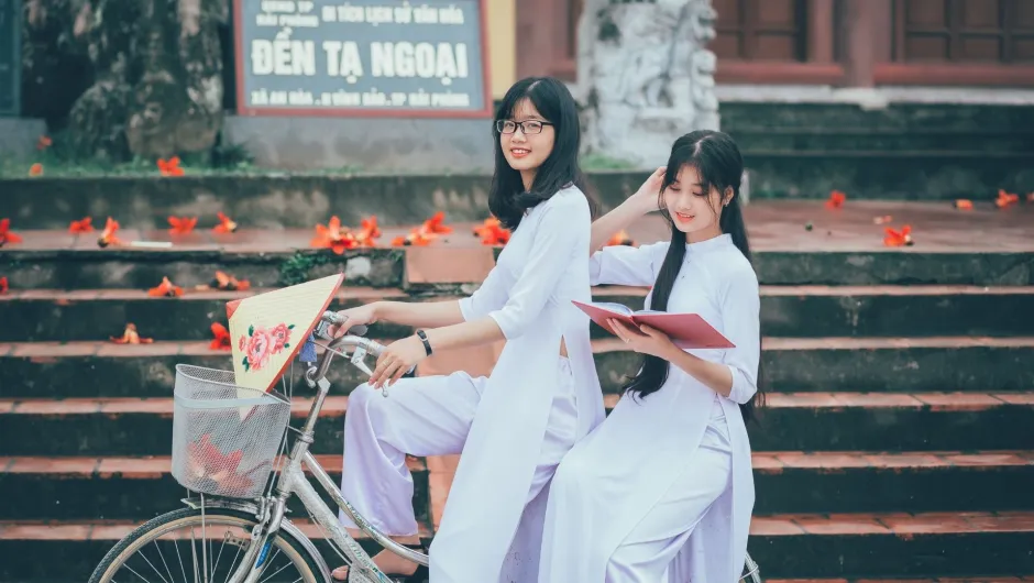 Nachhaltig Reisen in Vietnam, Fair unterwegs - Menschen mit typischen Vietnamesischen Strohhüten arbeiten am Wasser.